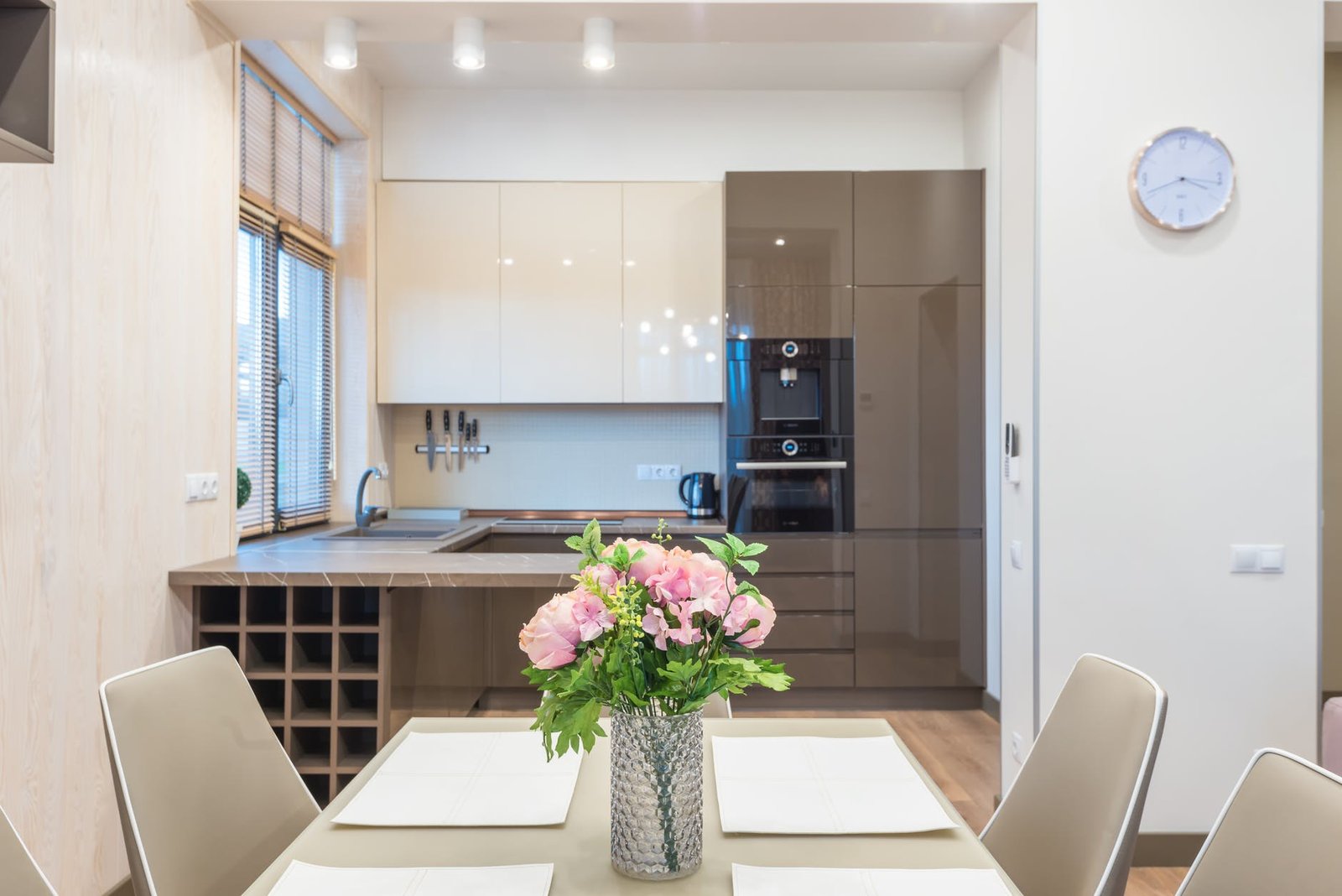kitchen with modern furniture and dining table decorated with bunch of fresh flowers