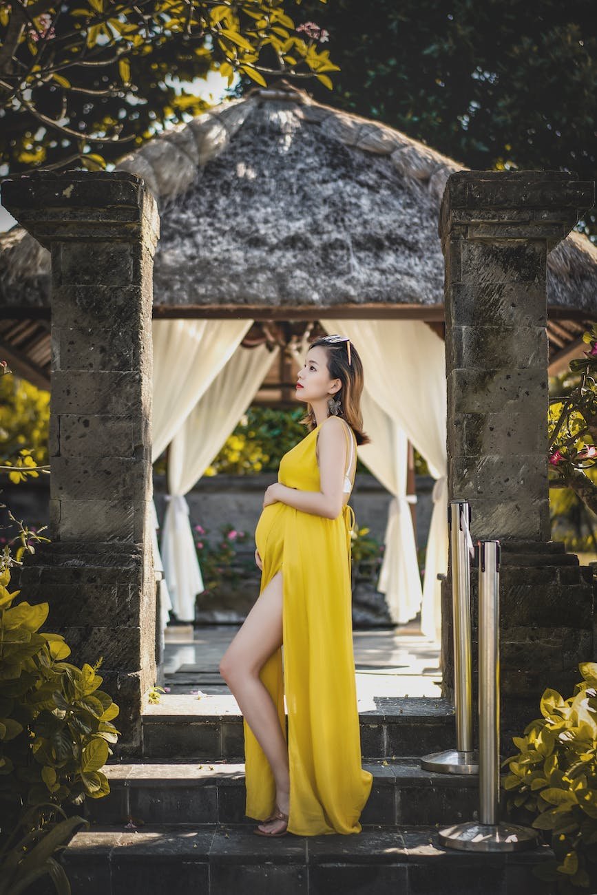 woman wearing yellow dress while standing on stairway